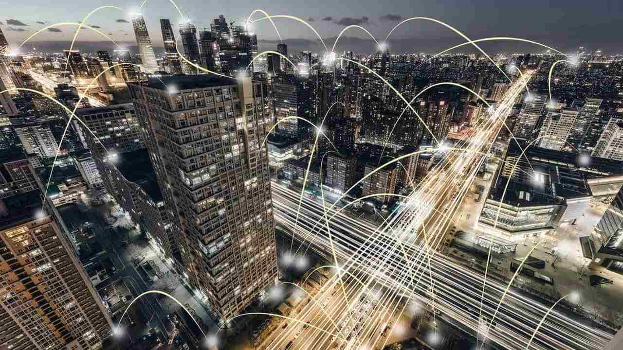 A sigla IoT, ou Internet das Coisas, refere-se à conexão de dispositivos físicos à internet para coletar e trocar dados. Quando falamos de IoT para cidades inteligentes, estamos nos referindo à aplicação dessa tecnologia no contexto urbano — como semáforos inteligentes, postes de iluminação que se adaptam ao movimento, sistemas de segurança conectados, sensores ambientais e muito mais.